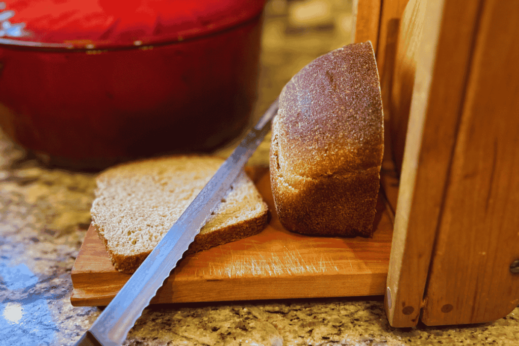 slicing bread on a bread slicer with a knife