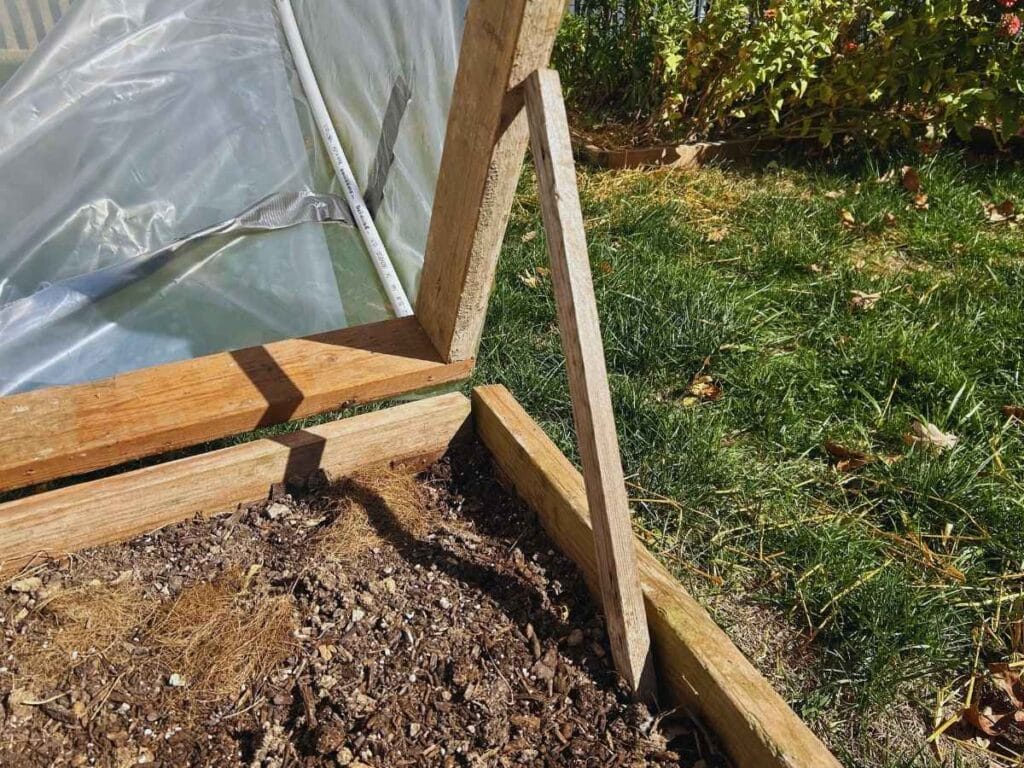 Stick holding up hinged greenhouse cover