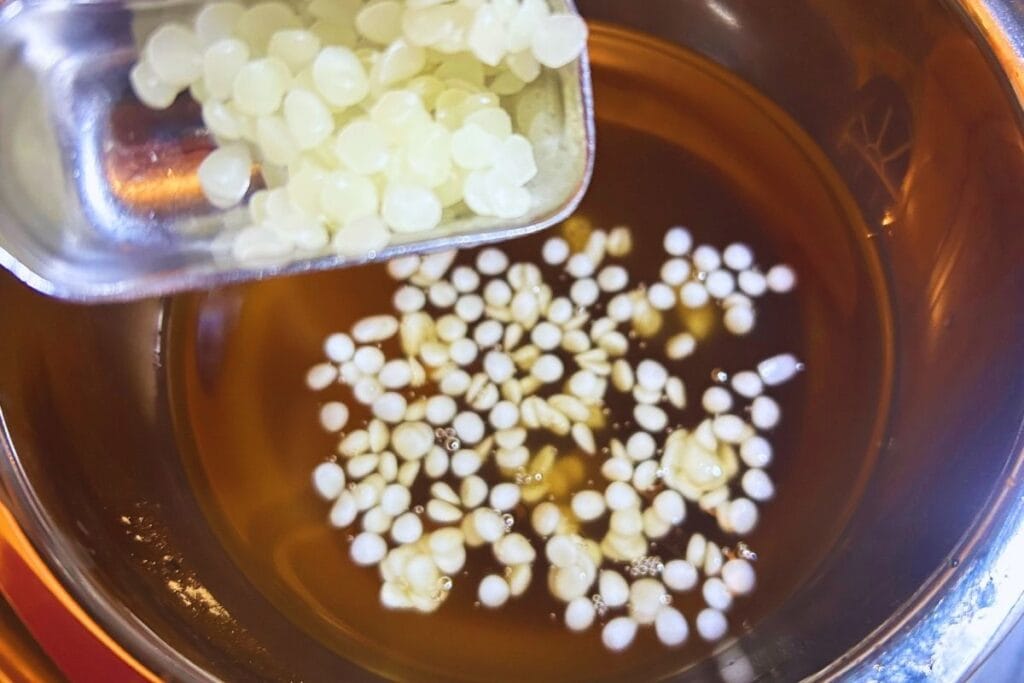 adding beeswax to melted tallow mixture in a double boiler
