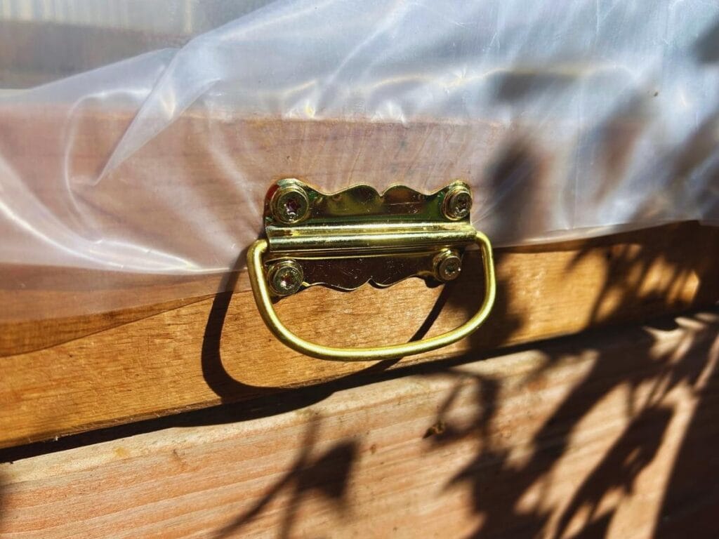 gold handle on a wood frame of a greenhouse