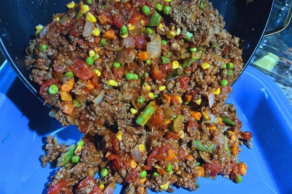 shepherds pie filling being dumped into casserole dish
