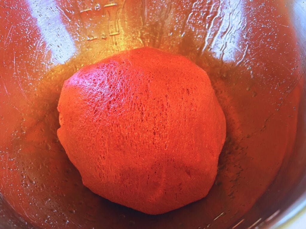kneaded pink dough in a ball in a bowl