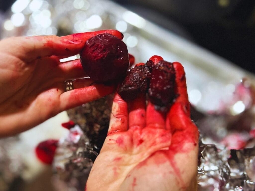 roasted beets being peel by hand