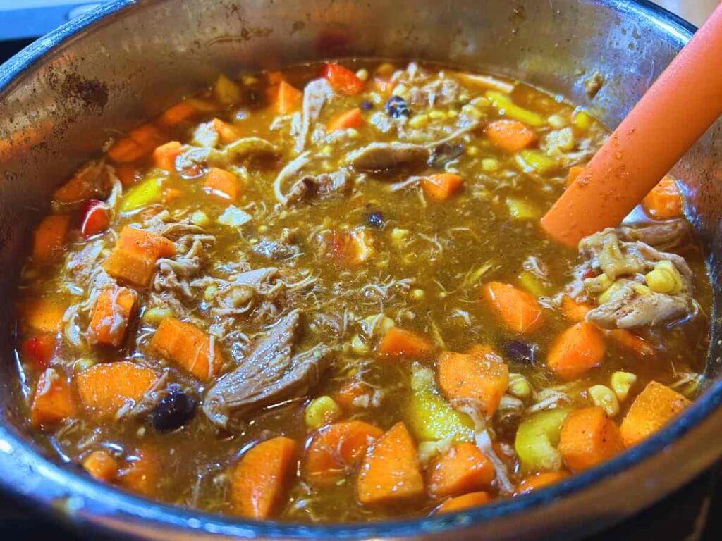 orange spatula stirring instant pot full of tortilla soup