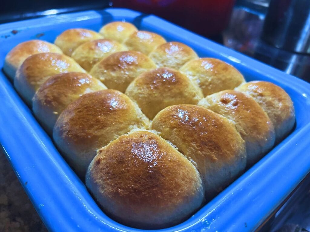 blue pan full of fresh homemade Hawaiian rolls