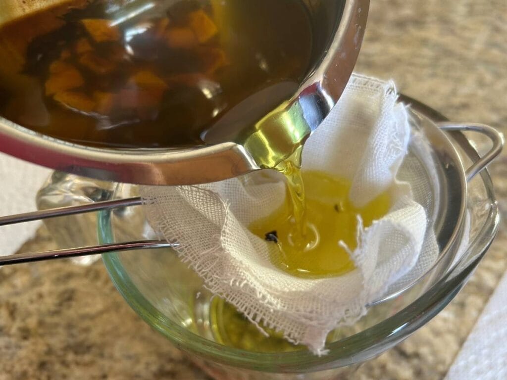 liquid citrus mint tallow lip balm being poured through cheese cloth