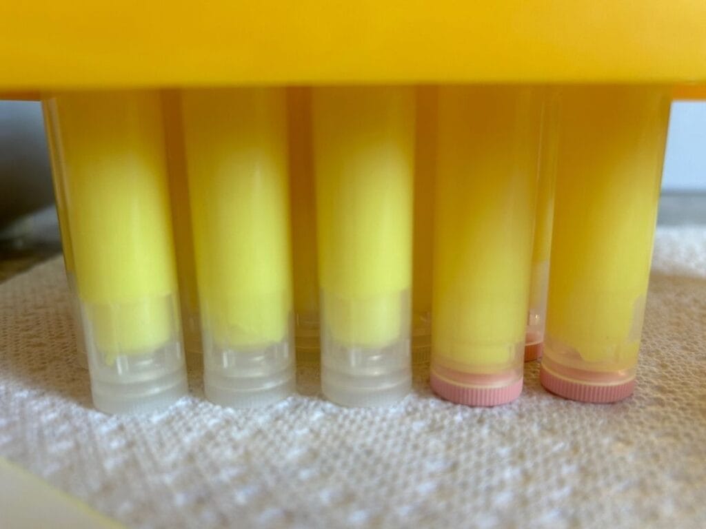 yellow lip balm in stick containers before labeling