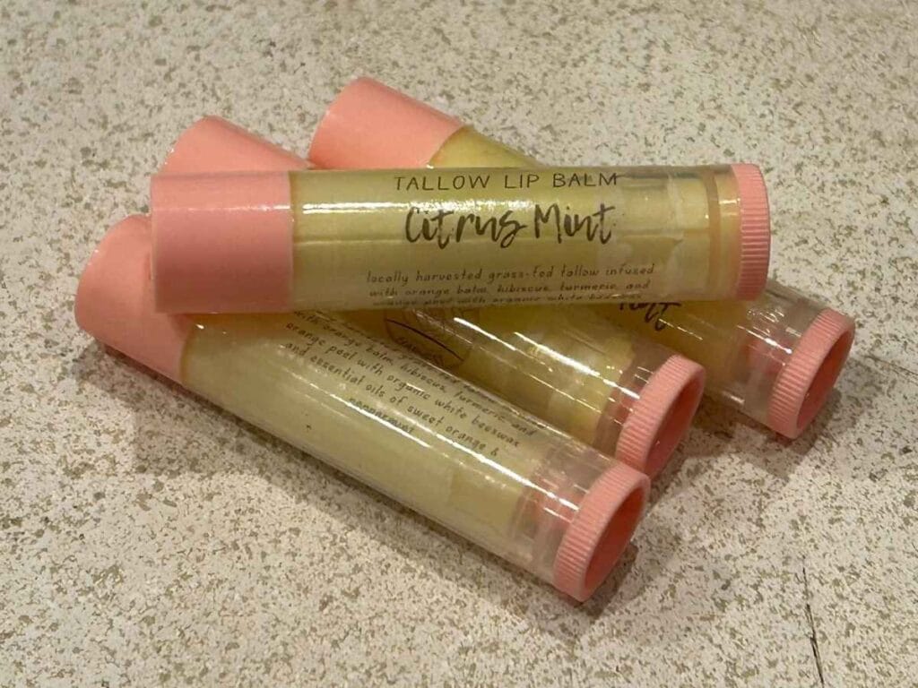citrus mint tallow lip balms stacked together on a stone surface