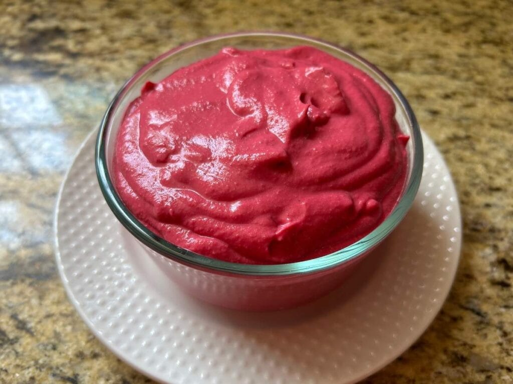 pink spread in a glass bowl on a white plate