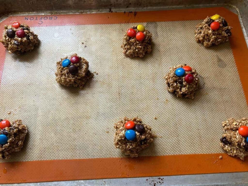 monster cookie dough balls on a silicone baking mat before cooking