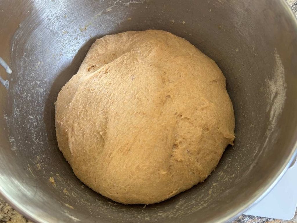 risen ball of dough in a metal bowl